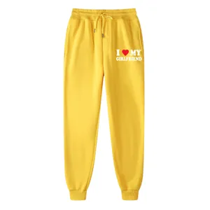 Detail of yellow cotton sweatpants featuring letter print and comfortable drawstring waist.