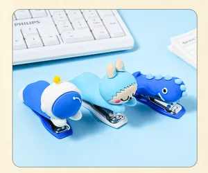 Close-up detail of cute cartoon animal and astronaut soft rubber staplers on blue desk.