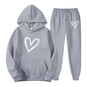 Casual gray hoodie and sweatpants tracksuit set featuring trendy white heart print design.