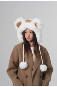 Detailansicht einer süßen Plüschmütze mit Bärenohren und Bommeln an einem asiatischen Model.