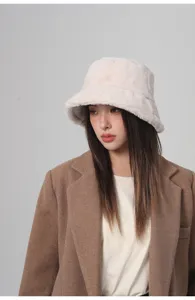 Primer plano de una modelo asiática que luce un gorro de invierno de felpa beige