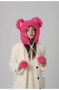 Asiatisches Model zeigt eine süße, leuchtend rosa Plüsch-Wintermütze mit Bommeln