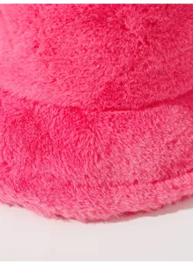 Primer plano de la suave textura de felpa rosa de este moderno gorro de pescador de invierno.