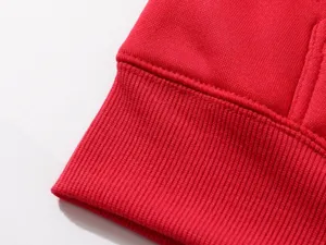 Detailed view of the red sweatshirt ribbed cuff, showing fine knit texture and neat stitching.