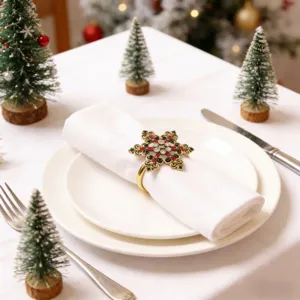 Weihnachtstisch Detailaufnahme mit glitzerndem Schneeflocken Serviettenring auf weißem Tuch.
