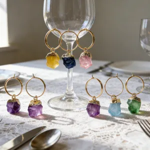 Vue détaillée de charmants marqueurs de verre à vin en cristal brut sur dentelle.