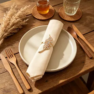 Dettaglio portatovagliolo con foglia d'oro e strass, decorazione tavola elegante.