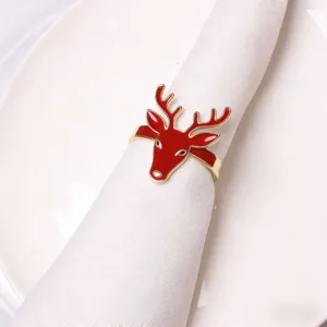 Close-up of red enamel and gold Christmas reindeer napkin ring detail for holiday table setting.