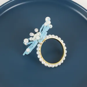 Detail van de prachtige parel libel servetring met blauwe kralen en gouden ring.