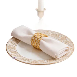 Portatovaglioli intrecciato dorato per tavola d'hotel, elegante decoro in metallo.