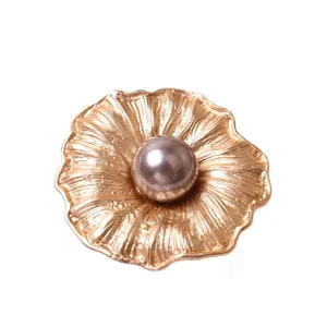 Portatovagliolo dorato a forma di fiore con perla al centro per una decorazione tavola elegante.
