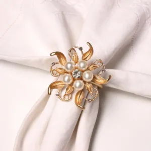 Dettaglio portatovagliolo floreale dorato, decorazione tavola europea ed elegante accessorio.