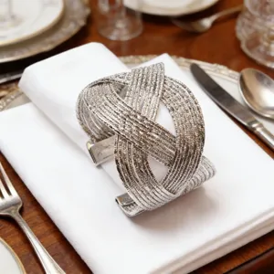 Détail de ronds de serviette tissés argentés, déco de table en métal pour dîner d'hôtel.