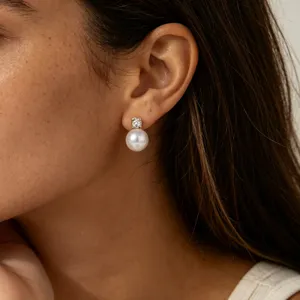 Close-up detail shot of elegant pearl and zircon stud earrings worn on ear gracefully.