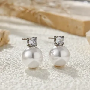 Detailed shot of elegant pearl and zirconia stud earrings with a refined minimalist design.