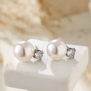 Elegant pearl and zircon stud earrings on a white stand, showcasing fine details and soft glow.