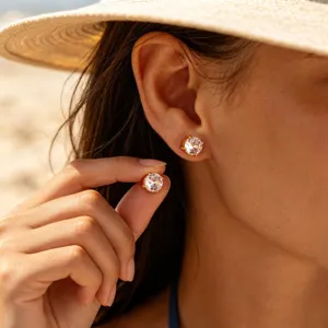 Close-up detail of stainless steel four-prong cubic zirconia stud earrings worn by model.