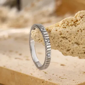 Close-up detail van de zilveren tandwiel patroon stapelbare ring met ronde stenen.