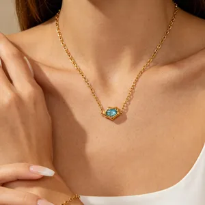 Gold-plated necklace close-up featuring an irregular blue zircon pendant, elegant detail view.