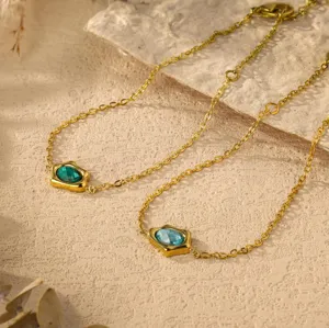 Gold-plated irregular zircon bracelet and necklace with green and blue faceted stones detail.