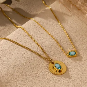 Detailed close-up shot of gold plated double layer necklaces with blue zircon stone pendants.