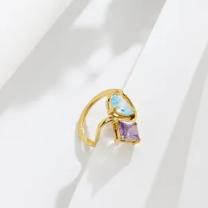 Close-up detail of the 18K gold-plated twin ring featuring blue and purple zirconia stones.