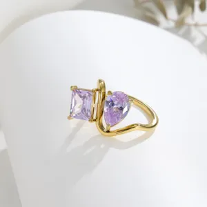 Detail shot of 18K gold plated twin ring featuring purple square and pear zirconia stones.