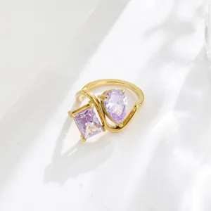 Detail shot of 18K gold plated purple cubic zirconia twin ring, elegant geometric hollow design.