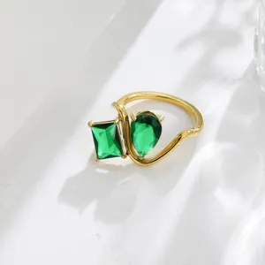 Exquisite 18K gold-plated dual green cubic zirconia ring, geometric openwork detail.