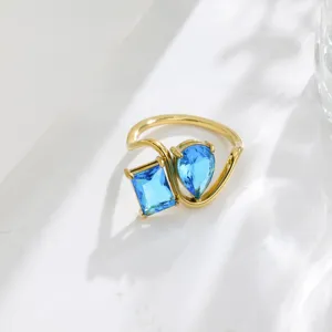 Detailed shot of the asymmetric twin blue cubic zirconia ring with gold-plated geometric band.