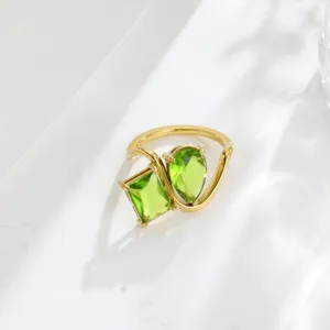 Close-up of the 18K gold plated two-stone green cubic zirconia open bypass ring detail.