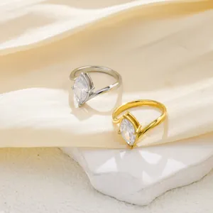 Primer plano de anillos elegantes de acero inoxidable con circón marquise para parejas.
