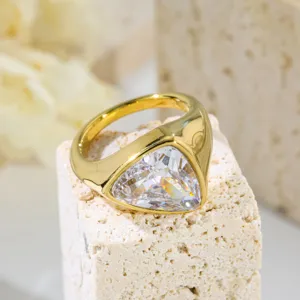 Close-up of a gold stainless steel ring with a large triangle zircon, stylish detail.
