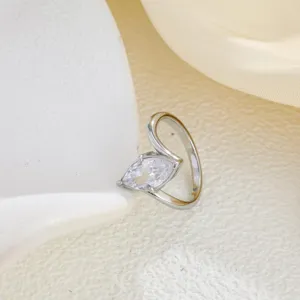 Primer plano detallado de un elegante anillo con circonita marquesa y banda de metal pulido.
