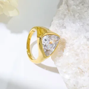 Detail view of a stylish gold stainless steel ring featuring a sparkling trillion cut cubic zirconia.