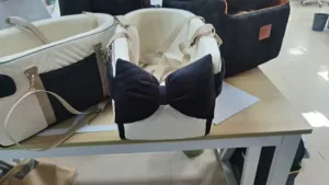 Small dog car seat portable pet carrier with cute black bow design for safe and comfortable travel.