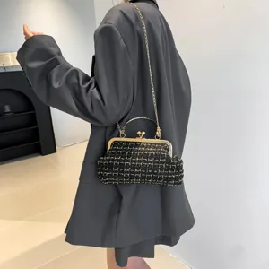 Vintage black and gold tweed handbag with gold chain strap and kiss lock closure.