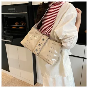 Detailed view of cream rivet punk style underarm bag featuring decorative metal eyelets