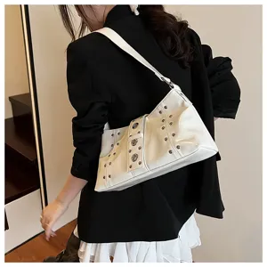Detailed view of white punk style rivet shoulder bag worn by model in black blazer