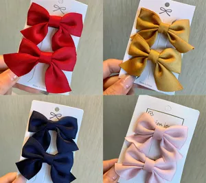 Primo piano di graziose mollette per capelli a fiocco in rosso, giallo, blu e rosa