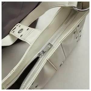 Close-up detail of white punk style motorcycle bag featuring silver rivets and metal zipper