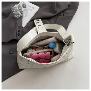 Interior view of the cream white rivet punk underarm bag showing its large storage capacity