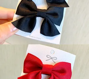 Primo piano di eleganti fermagli per capelli con fiocco in nastro rosso e nero