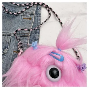 Close-up of pink plush monster crossbody bag showing long hair detail and colorful hair clips