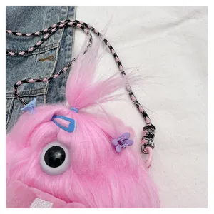 Detail of pink furry monster plush crossbody bag with cute hair clips and long hair