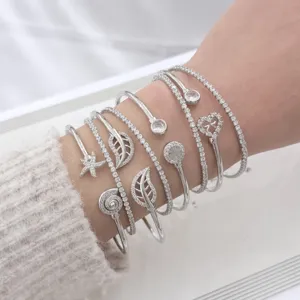 Elegante set di bracciali impilabili in argento con zirconi cubici e ciondoli chic.