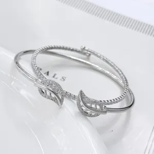 Primo piano di un elegante bracciale rigido in argento con dettagli di foglie in zircone.