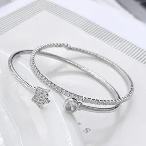Elegante pulsera doble de plata con diamantes brillantes y detalle de corona para mujer.