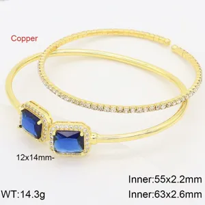 Detail shot of double gold bracelet with sparkling square blue zircon stones and crystal halo.