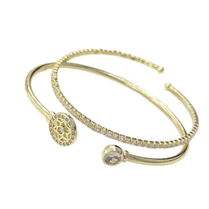 Elegante juego de pulseras abiertas doradas con pedrería brillante y diseño geométrico elegante.